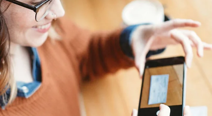 a hand putting a coin in a piggy bank