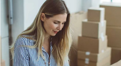 a hand putting a coin in a piggy bank